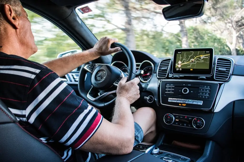 Man rijdt geconcentreerd in auto.